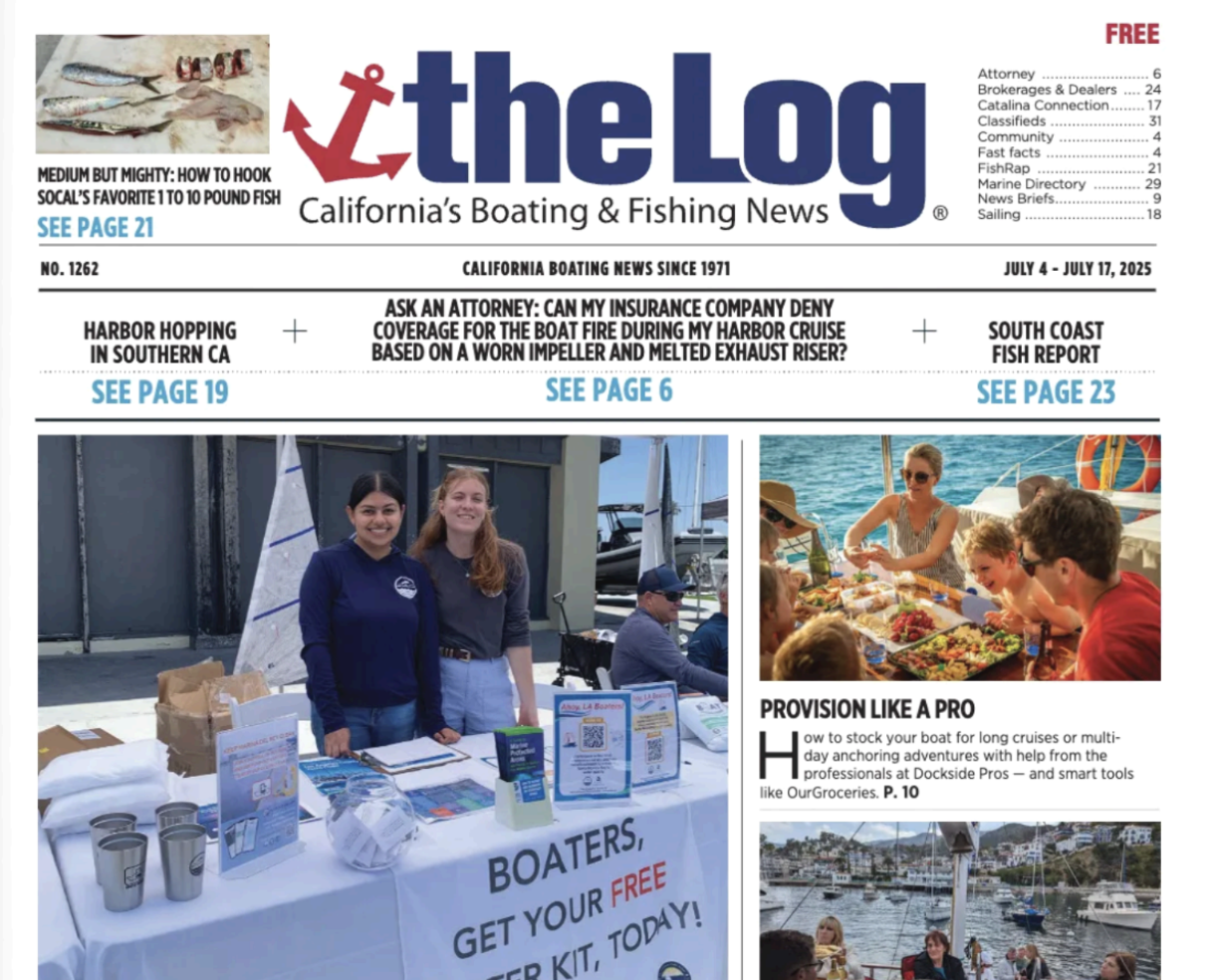 2 staffers behind a table with clean boating outreach materials on display